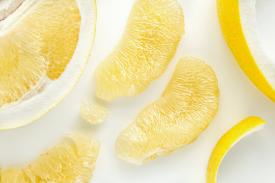 Fresh slices of juicy Chinese grapefruit on white background