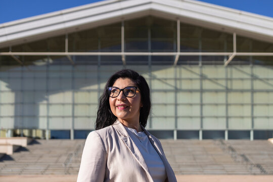 Confident businesswoman in front of modern architecture