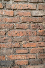 Obraz premium Close-up of weathered brick wall texture with visible mortar lines, showing rustic construction details and natural color variations.