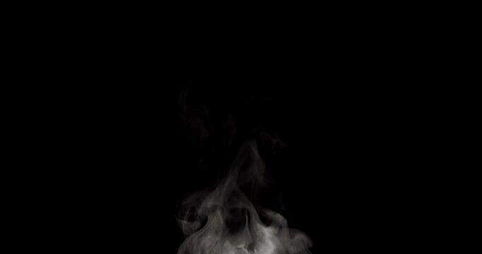 White isolated steam rises in light, graceful twists on a black background in slow motion This gentle trickle of steam is ideal footage as an overlay with blending modes Use this steam for hot drinks