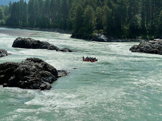 People on a catamaran are rafting down the Katun River, Altai, Russia