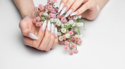 Woman's hands with white ombre stiletto nails holding flowers © Olena Rudo