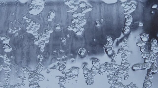 frozen ice and rain dropping down on window glass