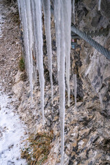 The Gleiersch Gorge in winter with snow, ice, and hanging icicles.