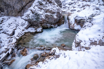 The Gleiersch Gorge in winter with snow, ice, and hanging icicles.