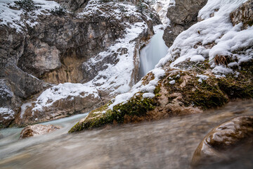 The Gleiersch Gorge in winter with snow, ice, and hanging icicles.