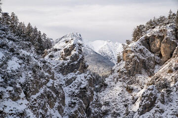 The Gleiersch Gorge in winter with snow, ice, and hanging icicles.