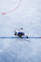 Clean composition top view ice hockey player crossing blue line during match play. Concept of game...