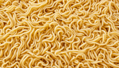 Close-up of cooked yellow ramen noodles from above. The angle is from above, showing the tangled strands of pasta under bright, even lighting.