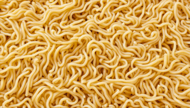 Close-up of cooked yellow ramen noodles from above. The angle is from above, showing the tangled strands of pasta under bright, even lighting.