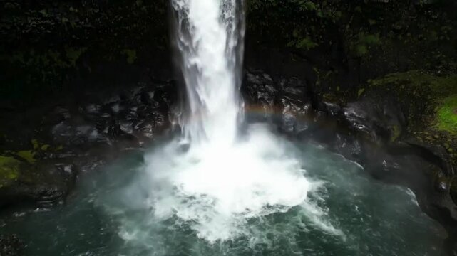The Silver Waterfall. Pristine Wilderness & Untouched Nature. Renewable Energy/Water. Waterfall cascading down a vertical mossy cliff, set in a hidden canyon with no human structures or access points.