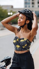 Confident black woman in fashionable cycling outfit adjusting helmet before urban ride in the city 