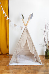 Interior of modern childroom with teepee. Children wigwam with hanging cotton flags for child play at home. Playroom with toys. scandinavian style. Festive decorated play tipi tent.   © stock_studio