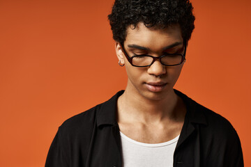 Obraz premium Stylish young man in glasses exudes confidence in a vibrant studio setting