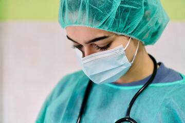 Medical Professional in Surgical Gown Wearing Mask and Cap with Stethoscope, Preparing Sterile Environment Today