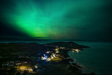 Fototapeta premium The Aurora Borealis, the northern lights, showing up above Portnoo harbour in County Donegal, Ireland