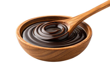 Wooden spoon stirring dark molasses in a bowl isolated on transparent background
