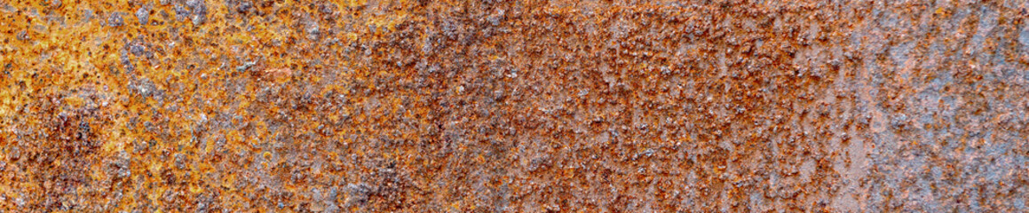 Rusty metal surface showing corrosion and oxidation effects. Weathered wall surface.