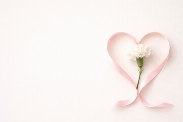 Fototapeta premium Delicate heart shape with a flower and ribbon on a soft background.