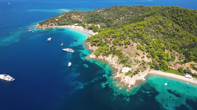 Aerial 4K Close-up of Twin Beaches at Tsougria Island Near Skiathos Greece with Luxury Yachts Anchored in Turquoise Bay and Rocky Coastline
