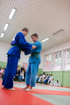Two young athletes show their judo skills in front of the coaches