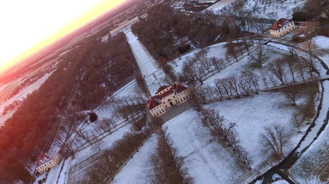 Luftansicht der historischen Schlossanlage Schleissheim nahe Muenchen. Drohnenvideo zeigt barocke Architektur, verschneite Gaerten und gefrorene Kanaele.