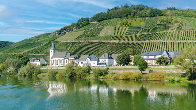 Picturesque wine village berncastell kues with church on moselle river embankment in germany