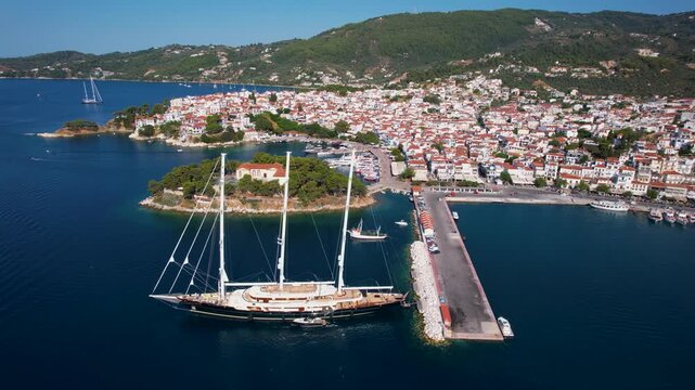 Aerial 4K View of Skiathos Old Town and Bourtzi with Giant Three-Masted Frigate Sailing Ship Moored at Port in Greece