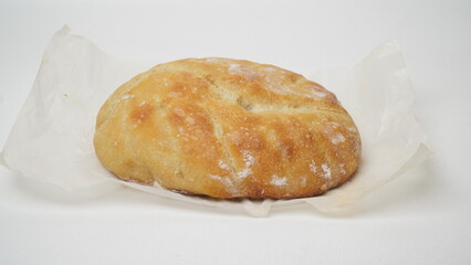 Hands holding whole sourdough bread on a white background.