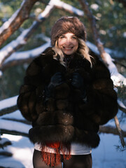 Smiling woman in luxury fur hat. Slavic style winter fashion portrait