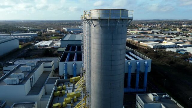 Drone footage of a power station in Hoddesdon UK with prominent electricity pylons and substation transformers for the national electricity grid.