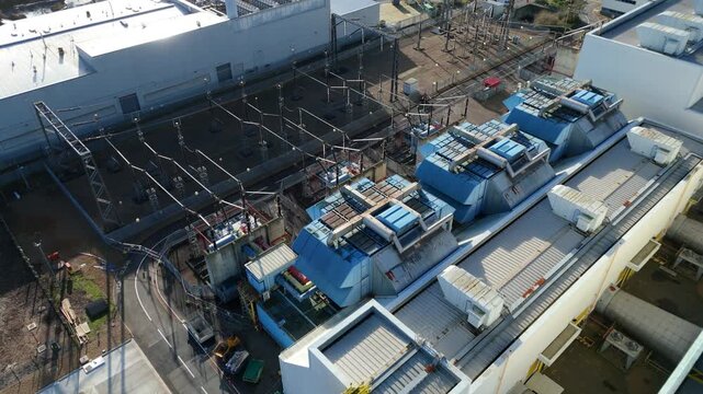 Drone footage of a power station in Hoddesdon UK with prominent electricity pylons and substation transformers for the national electricity grid.
