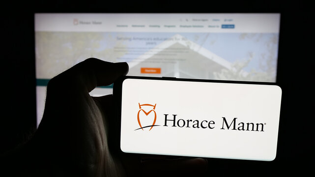 Stuttgart, Germany - 01-16-2026: Person holding mobile phone with logo of US company Horace Mann Educators Corporation on screen in front of web page. Focus on phone display.