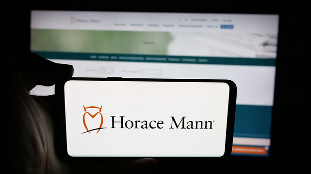 Stuttgart, Germany - 01-16-2026: Person holding cellphone with logo of US company Horace Mann Educators Corporation on screen in front of webpage. Focus on phone display.