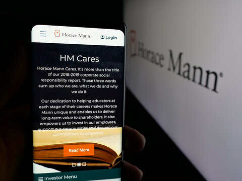 Stuttgart, Germany - 01-16-2026: Person holding cellphone with webpage of US company Horace Mann Educators Corporation on screen in front of logo. Focus on center of phone display.