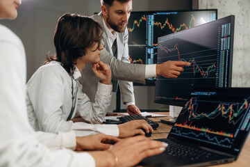 Side view, man is giving advises. Business people are working with stock market exchange in office