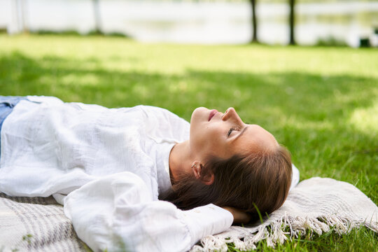 Woman napping relaxed in park during sunny summer day