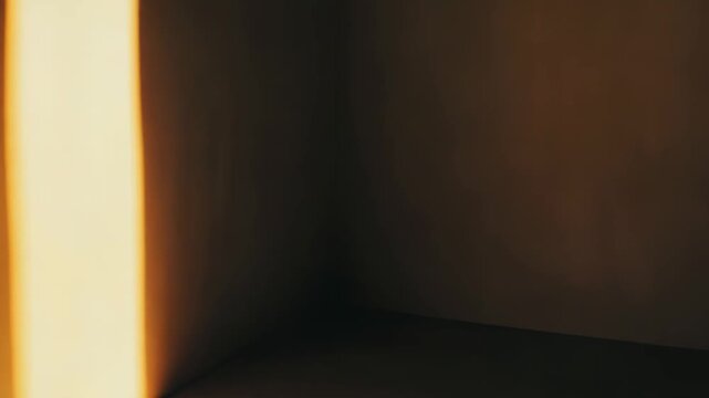 Sunlight casting strong, parallel light and shadow patterns across two converging walls and the floor, creating a minimalist, atmospheric, and geometric abstract composition