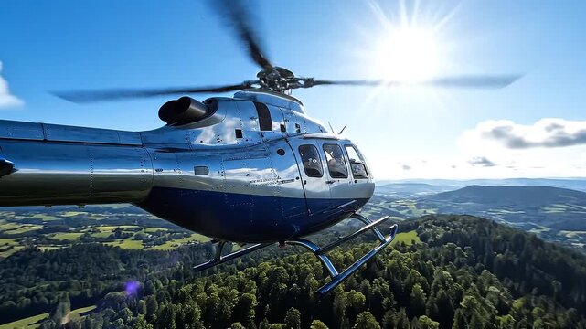 A silver helicopter flying over a forested landscape with a sunny blue sky and white clouds in the background, possibly for tourism or aerial photography use