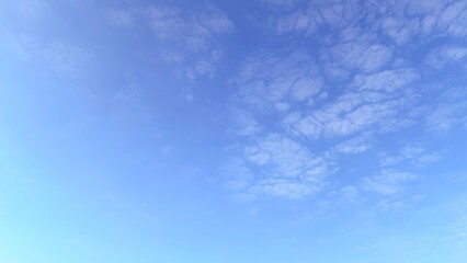 Bright blue sky with soft white clouds on a clear sunny day