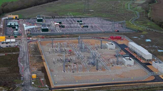 Close up aerial view of 400kV substation featuring supergrid transformers and high voltage pylons for the Great Grid Upgrade near Biggleswade United Kingdom. 