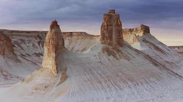 Aerial view of towering sandstone formations exhibit contrasting colors and textures against the vast landscape, Aktau, Mangystau Region, Kazakhstan.