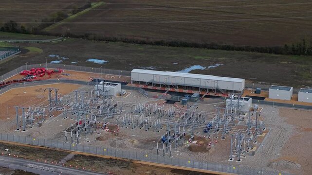 Close up aerial view of 400kV substation featuring supergrid transformers and high voltage pylons for the Great Grid Upgrade near Biggleswade United Kingdom. 