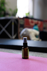 Amber Glass Spray Bottle on Pink Yoga Mat for Aromatherapy or Sanitizing