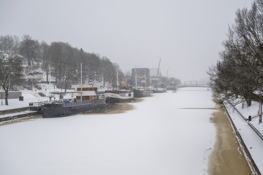 Ships moored on the banks of the frozen Aurajoki River, wintery Turku or Swedish &Aring;bo, Varsinais-Suomi, Finland