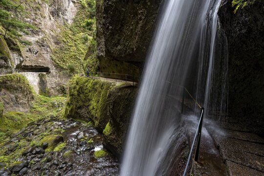 Hikers at Levada Nova, Nova waterfall and Moinho in a gorge, long exposure, Ponta do Sol, Madeira, Portugal