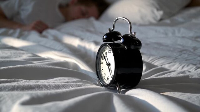 Retro clock on bedside table near woman sleeping in bed. Time flows calmly in cozy bedroom. Alarm waits for morning. Bed, alarm, time and relax moment with sleeping woman resting in calm bedroom