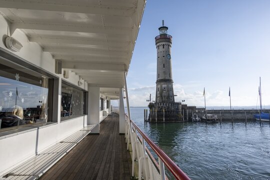 Outside deck of a passenger ship, leaving Lindau harbour with New Lindau Lighthouse, Lindau Island, Lake Constance, Bavaria, Germany