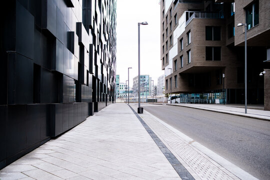 Quiet modern city street with urban architecture and sidewalk showing empty perspective for transport corridor with clean daylight lines