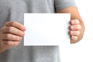 Obraz premium A person holds a blank white card with both hands, showcasing a simple and clean presentation against a neutral background.